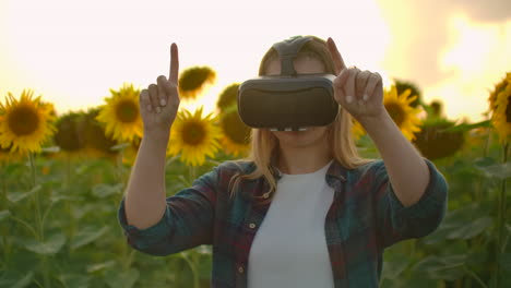 The-girl-is-working-in-VR-glasses.-She-is-engaged-in-the-working-process.-It-is-a-perfect-sunny-day-in-the-sunflower-field.